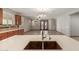 Modern kitchen with a stylish island, stainless steel sink, and bright lighting, seamlessly flowing into the living area at 16229 W Jenan Dr, Surprise, AZ 85379