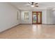 Inviting living room with tile flooring, ceiling fan, and glass panel doors for ample natural light at 16229 W Jenan Dr, Surprise, AZ 85379