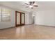 Spacious living room with tile floors, ceiling fan, and glass panel doors for natural light at 16229 W Jenan Dr, Surprise, AZ 85379