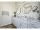Modern bathroom with double sinks, granite countertops, and stylish round mirrors at 17324 E Quail Track Rd, Rio Verde, AZ 85263