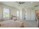 Bright bedroom with neutral carpet and walls, featuring a dresser and views of the landscape at 17324 E Quail Track Rd, Rio Verde, AZ 85263