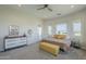 Comfortable bedroom with ample natural light, a dresser, and a cozy yellow bench at the foot of the bed at 17324 E Quail Track Rd, Rio Verde, AZ 85263
