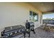 Covered patio featuring a built-in outdoor kitchen with a modern flat top grill and additional smoker at 17324 E Quail Track Rd, Rio Verde, AZ 85263