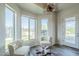 Bright sitting room featuring modern light fixture, wood floors, and outdoor views from the three large windows at 17324 E Quail Track Rd, Rio Verde, AZ 85263