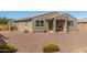 Spacious backyard featuring desert landscaping with a covered patio, offering a private and relaxing outdoor space at 17971 W Meadowbrook Ave, Goodyear, AZ 85395