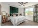 Stylish bedroom with a large green upholstered headboard and neutral decor at 17971 W Meadowbrook Ave, Goodyear, AZ 85395