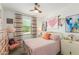 Charming bedroom featuring a unique metal bed frame, soft pink quilt, and stylish decor at 17971 W Meadowbrook Ave, Goodyear, AZ 85395