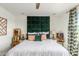 Cozy bedroom featuring decorative pillows and a green upholstered headboard at 17971 W Meadowbrook Ave, Goodyear, AZ 85395