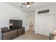Versatile bedroom with white walls, neutral carpet, TV, a closet and a ceiling fan at 17971 W Meadowbrook Ave, Goodyear, AZ 85395