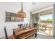 Charming dining area with a rustic wooden table, bench seating, stylish decor, and sliding door to the patio at 17971 W Meadowbrook Ave, Goodyear, AZ 85395