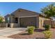 Stylish one-story home with a desert front yard, showcasing its tidy facade and attached two-car garage at 17971 W Meadowbrook Ave, Goodyear, AZ 85395