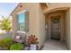 Inviting entryway with charming decor, including a welcome mat, rustic windmill, and a quaint bench at 17971 W Meadowbrook Ave, Goodyear, AZ 85395