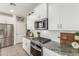 Contemporary kitchen boasts granite counters, stainless appliances, and white cabinets at 17971 W Meadowbrook Ave, Goodyear, AZ 85395