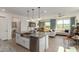 Open kitchen flows to the living area, featuring an island and stainless appliances at 17971 W Meadowbrook Ave, Goodyear, AZ 85395