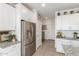 Kitchen features stainless refrigerator, granite countertops and white cabinets at 17971 W Meadowbrook Ave, Goodyear, AZ 85395