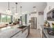Open-concept kitchen with granite island, stainless sink, and breakfast bar seating at 17971 W Meadowbrook Ave, Goodyear, AZ 85395