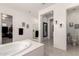 This primary bathroom features a standalone tub, walk-in shower, and lots of natural light at 18134 W Highland Ave, Goodyear, AZ 85395