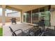 View of a covered patio with dining set and grill, perfect for outdoor living and entertaining at 18134 W Highland Ave, Goodyear, AZ 85395