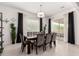 Dining room with a contemporary chandelier, a dark wood table, seating for eight, and natural lighting at 18134 W Highland Ave, Goodyear, AZ 85395