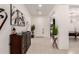 Inviting foyer with a tiled floor, decorative console table, and a view into the game room at 18134 W Highland Ave, Goodyear, AZ 85395