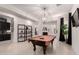 Open game room with a pool table, and a view into the kitchen and living area at 18134 W Highland Ave, Goodyear, AZ 85395