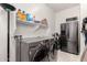 Functional laundry room with stainless steel appliances, storage shelves and a convenient refrigerator at 18134 W Highland Ave, Goodyear, AZ 85395