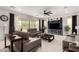 Spacious living room with stylish leather sofas, a modern ceiling fan, and lots of natural light at 18134 W Highland Ave, Goodyear, AZ 85395