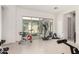 Tiled workout area with gym equipment and sliding door access to the backyard patio at 18134 W Highland Ave, Goodyear, AZ 85395