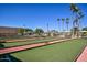 Several bocce ball courts surrounded by mature trees and picnic tables under a clear blue sky at 18610 N Mica Dr, Sun City West, AZ 85375