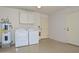 Functional laundry area featuring a side by side washer and dryer, with storage cabinets, and access door at 18610 N Mica Dr, Sun City West, AZ 85375