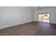 Bright living room featuring vaulted ceilings, wood-look tile floors, and sliding glass doors to the patio at 18610 N Mica Dr, Sun City West, AZ 85375
