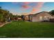 Wide view of backyard featuring covered patio, volleyball net, and lush lawn with seating areas at 19203 S 185Th Dr, Queen Creek, AZ 85142