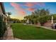 Lush backyard with large grassy area, lounge chairs, mature trees, and perimeter landscaping at 19203 S 185Th Dr, Queen Creek, AZ 85142