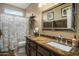 Stylish bathroom with a modern vanity, granite countertops, and a shower with patterned curtain at 19203 S 185Th Dr, Queen Creek, AZ 85142