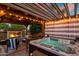 Relaxing covered patio with hot tub, ambient lighting, fireplace, and dining area at 19203 S 185Th Dr, Queen Creek, AZ 85142