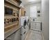 Functional laundry room with washer, dryer, built-in storage, and decorative touches at 19203 S 185Th Dr, Queen Creek, AZ 85142