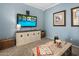 Cozy living room with blue walls, a large TV, and a wooden coffee table with games at 19203 S 185Th Dr, Queen Creek, AZ 85142