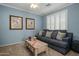 Comfortable living room with blue walls, neutral carpet, plantation shutters and coastal decor at 19203 S 185Th Dr, Queen Creek, AZ 85142