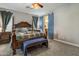 Comfortable main bedroom featuring a four-poster bed, soft lighting, and stylish blue doors to an ensuite bathroom at 19203 S 185Th Dr, Queen Creek, AZ 85142