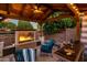 Inviting outdoor covered seating area with fireplace, fan, wine, and comfortable furniture at 19203 S 185Th Dr, Queen Creek, AZ 85142