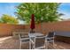 Inviting backyard with outdoor dining area, complete with chairs, table, and an umbrella for shade at 1933 E Lafayette Ave, Gilbert, AZ 85298