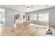 Large, open-concept living room showing wood-look flooring and access to the kitchen, staged virtually at 1933 E Lafayette Ave, Gilbert, AZ 85298