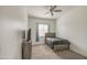 Cozy bedroom features wood-look flooring, TV, and a large window at 19742 W Harrison St, Buckeye, AZ 85326
