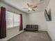 Carpeted bedroom featuring a ceiling fan, a leather futon and a TV set on the wall at 19742 W Harrison St, Buckeye, AZ 85326