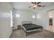 Bright bedroom featuring a ceiling fan, carpeted floor and a bed with black metal frame at 19742 W Harrison St, Buckeye, AZ 85326