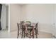 Dining table with four wood chairs and black cushions featuring a white wall on a tiled floor at 19742 W Harrison St, Buckeye, AZ 85326