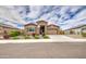 Inviting home with a stone entrance, beautiful shrubs, and a well-maintained lawn at 19742 W Harrison St, Buckeye, AZ 85326