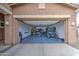 Spacious garage featuring an open door to reveal epoxy floors and a utility vehicle at 19742 W Harrison St, Buckeye, AZ 85326
