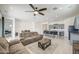 Open-concept living room with neutral decor, ceiling fan, and seamless flow to kitchen at 19742 W Harrison St, Buckeye, AZ 85326
