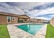 Backyard with a pool, patio area, and lush artificial grass at 19742 W Harrison St, Buckeye, AZ 85326